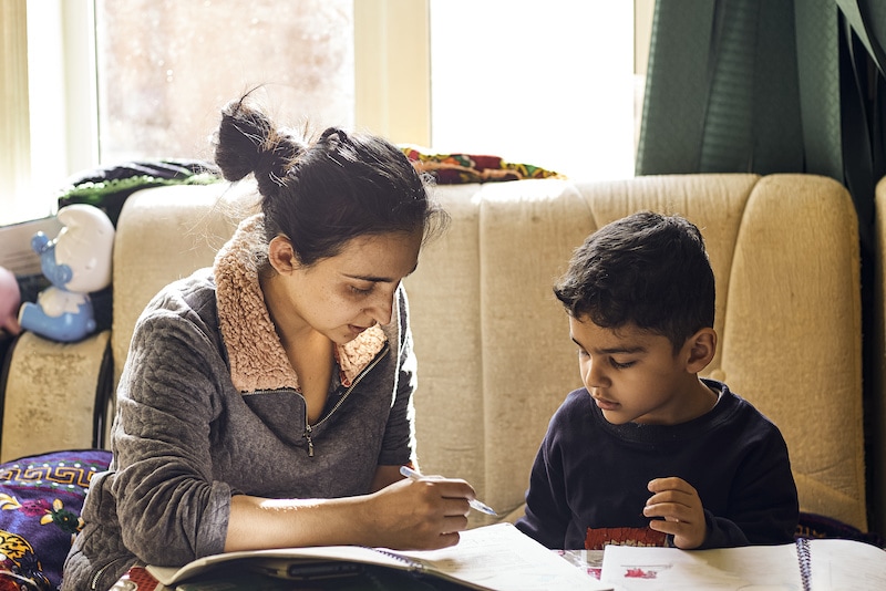 Parenting help with homework. Authentic photo of young mother helping her little boy do homework